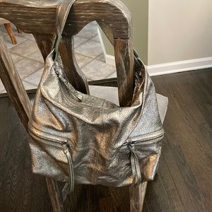 Distressed metallic satchel. 4 outside & 3 inside pockets and a zip closure